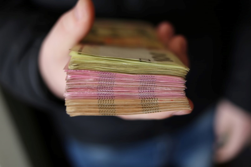 Close-up of a hand holding a wad of cash.